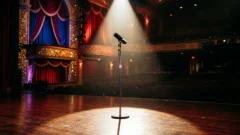 Microfone elegante e silencioso sob holofote dramático em palco Las Vegas, sugerindo interrupção súbita da transmissão ao vivo.